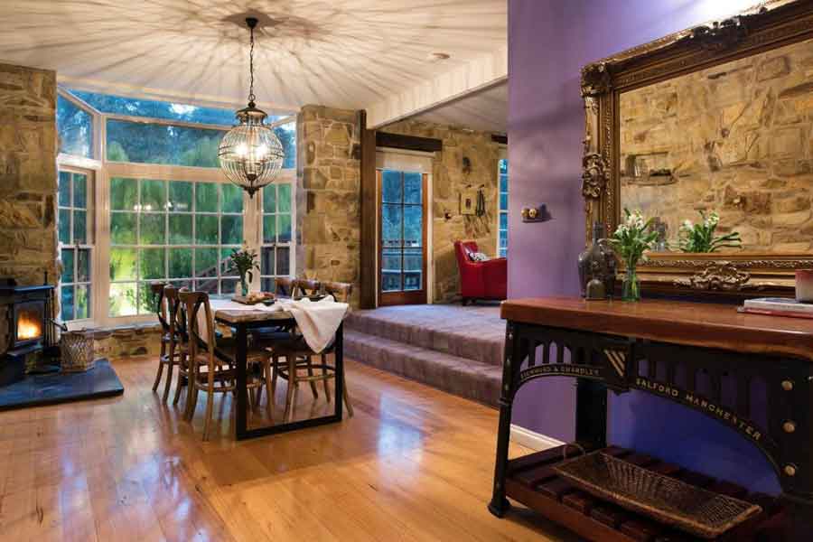 Dining area beneath a chandelier, with garden views