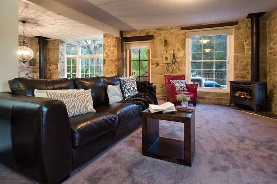 Living room with stone walls, leather sofa and gas heater